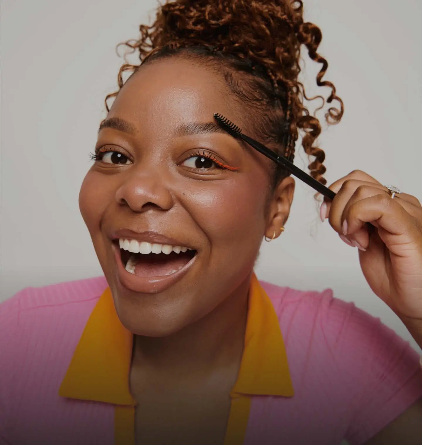 smiling woman brushing her brows after a brow treatment from Ivy Reign